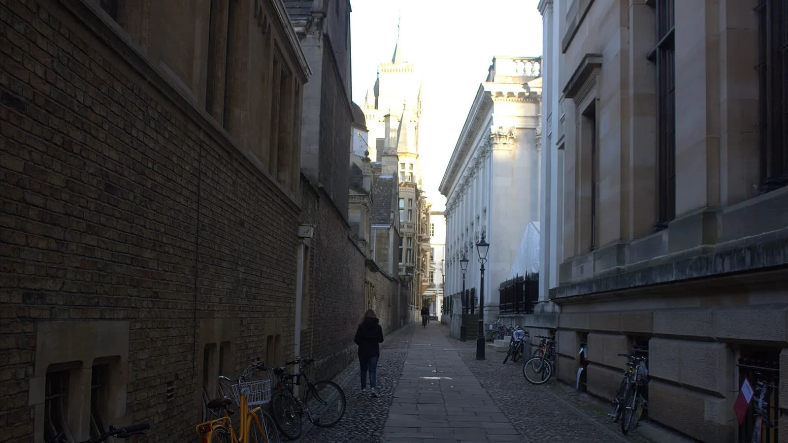 The narrow cobbled Senate House Passage between college buildings in Cambridge